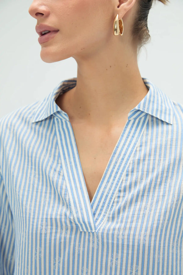 Close-up of striped popover blouse neckline featuring subtle lace trim and clean finish