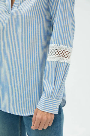 Detail view of striped popover blouse sleeve showing delicate lace and relaxed construction