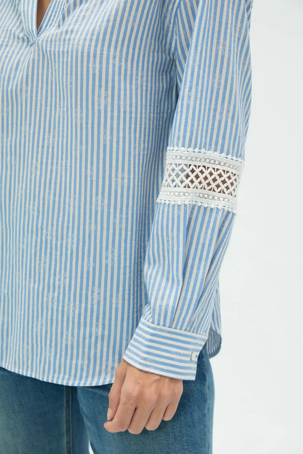 Detail view of striped popover blouse sleeve showing delicate lace and relaxed construction