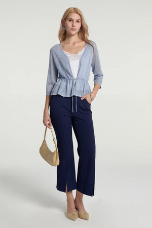 Tailored kick-flare trousers styled with a light blue cardigan for an elevated, modern look