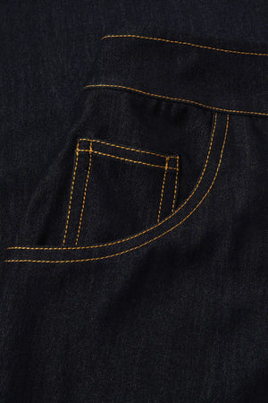Detail view of the front pocket design with contrast stitching on dark wash denim