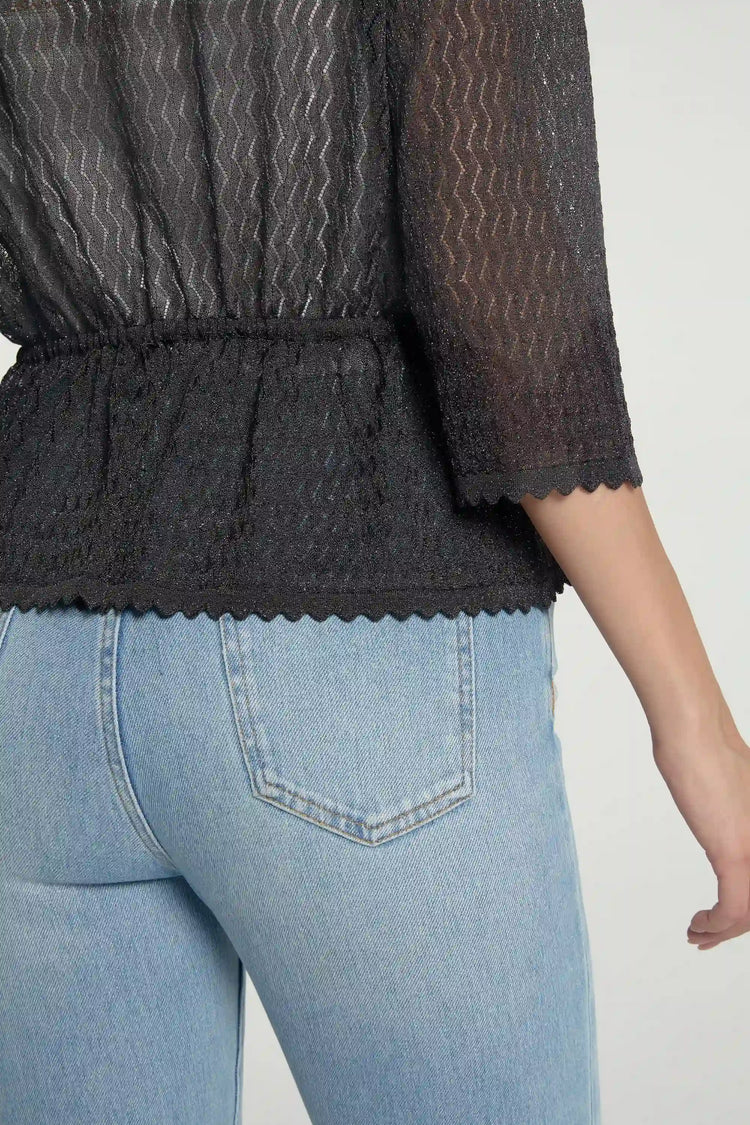 Close-up of shadow black textured peplum cardigan fabric showing delicate knit texture