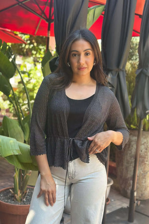 Women’s shadow black textured peplum tie-front cardigan styled with white jeans, full-body front view