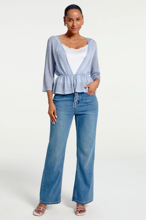 Women’s soft blue textured peplum tie-front cardigan styled with blue jeans, full-body front view