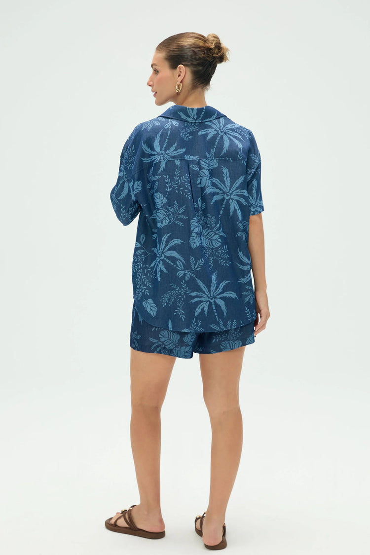 Back view of women’s tropical print button-up shirt styled with matching shorts