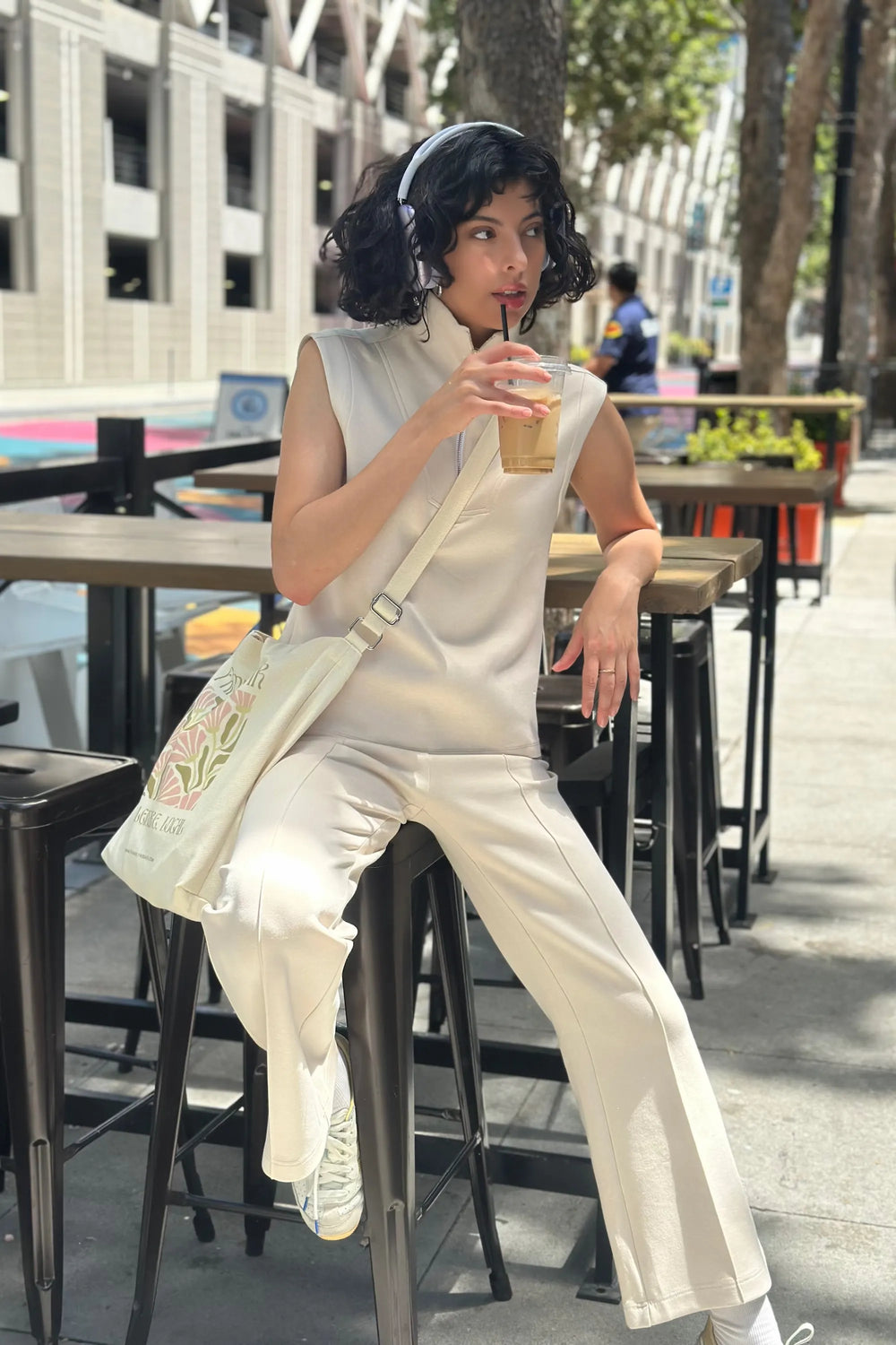 Modern zip-collar sleeveless pullover in cream sandshell styled with matching pants, front view on grey background