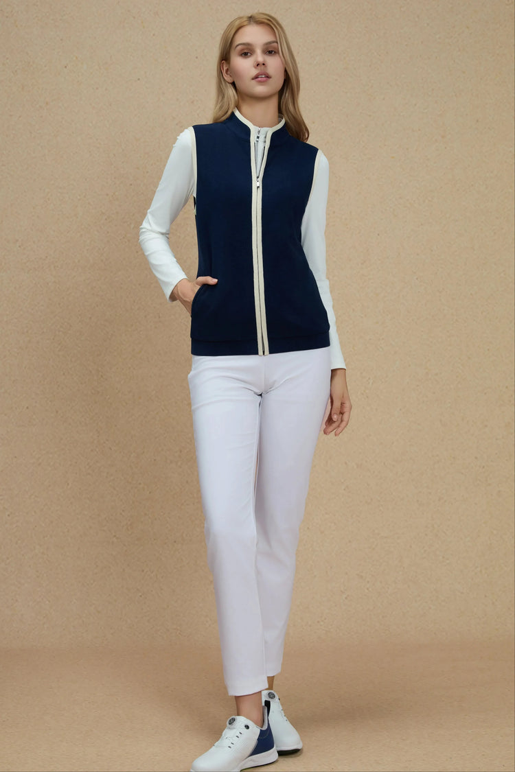 Navy zip-front vest styled with white athletic trousers for a clean, modern look