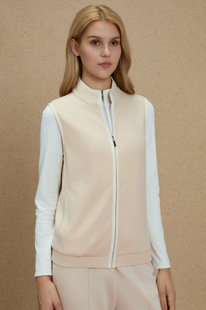 Zip-front vest in Oatmilk Beige layered over a white long-sleeve top, front view