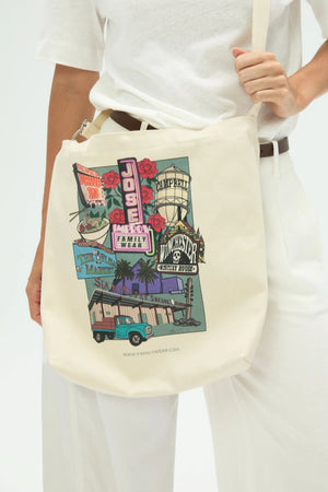 Everyday canvas tote with San Jose postcard print worn crossbody, front view