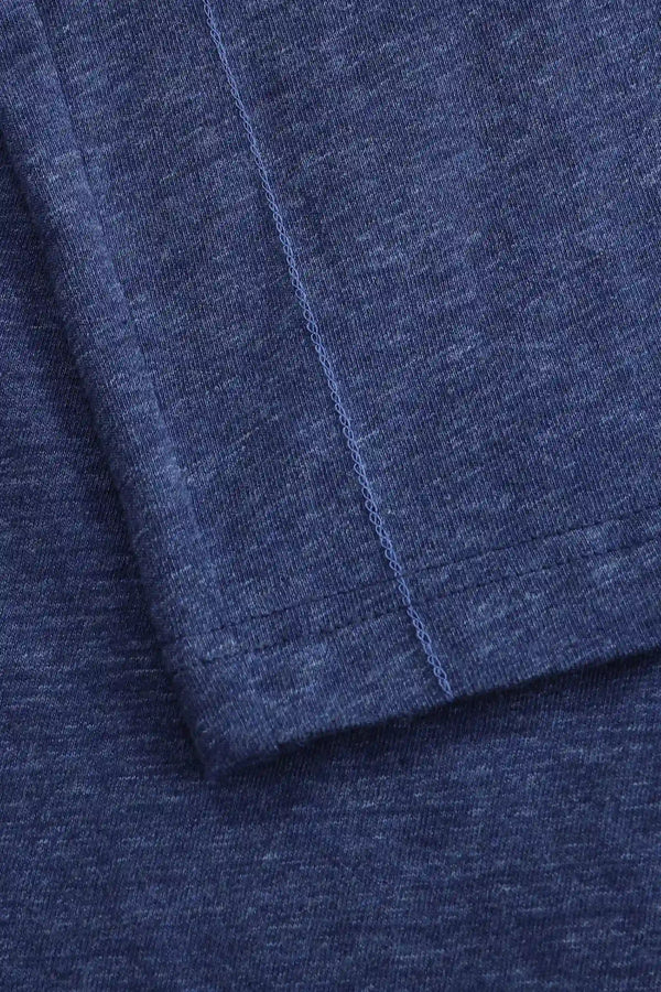 Detail of the hem finish on a men’s maritime blue cotton-Tencel long-sleeve polo.