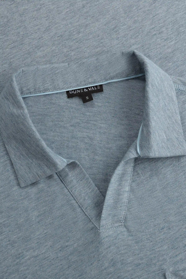 Close-up of the relaxed open-collar neckline on a men’s steel blue cotton-Tencel polo.