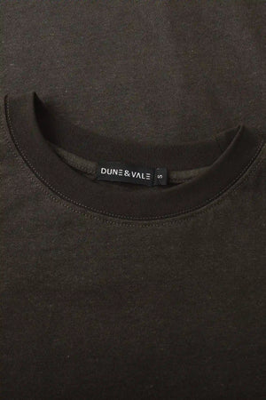 Close-up of the crewneck collar on a men’s espresso linen–Supima tee.