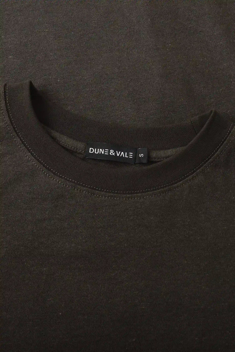 Close-up of the crewneck collar on a men’s espresso linen–Supima tee.