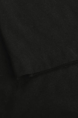 Detail of the hem finish on a men’s jet black linen–Supima crewneck tee.