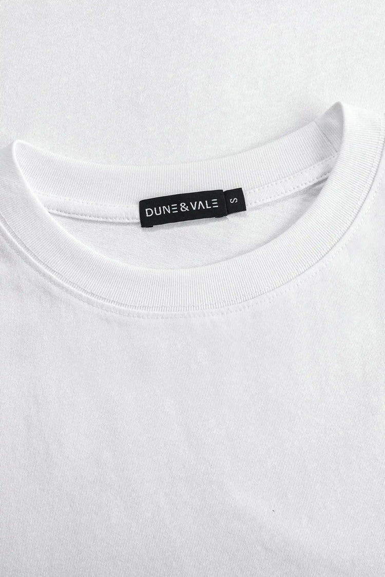 Close-up of the crewneck collar on a men’s pure white linen–Supima tee.