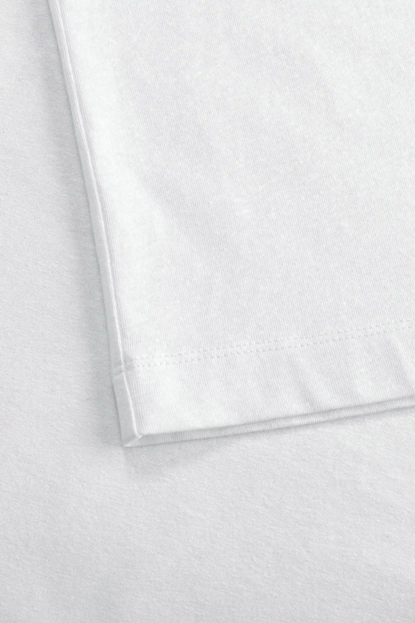 Detail of the hem finish on a men’s pure white linen–Supima crewneck tee.