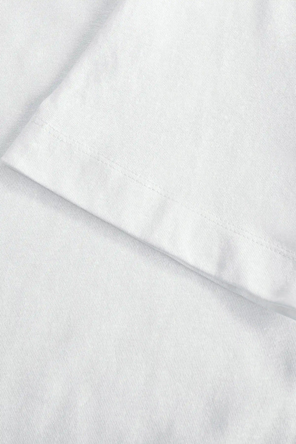 Detail view of the sleeve finish on a men’s pure white linen–Supima crewneck tee.