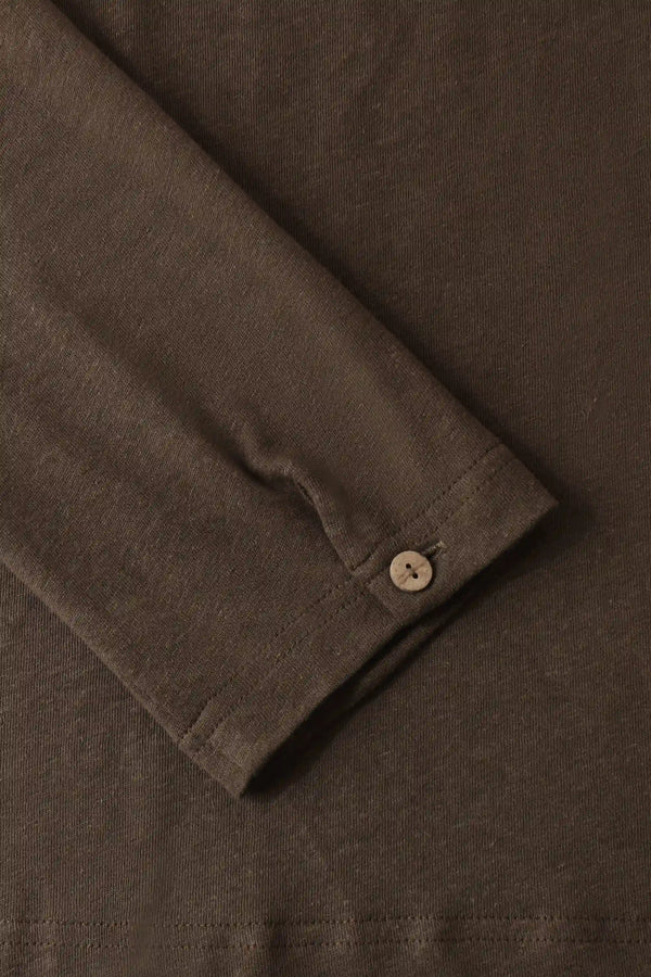Detail view of the single-button cuff on a men’s espresso linen–Supima henley, designed for clean, refined ease.