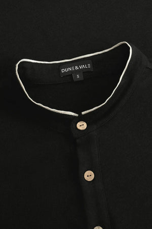 Close-up of the button-neck mandarin collar on a men’s onyx black linen–Supima henley.