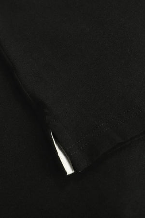 Detail of the subtle side slit at the hem of a men’s onyx black linen–Supima button-neck henley.