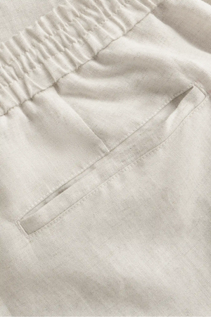 Detail view of the back pocket on men’s driftwood beige linen-Tencel drawstring trousers, designed for everyday ease.