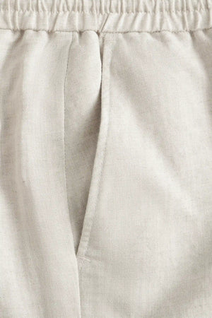 Detail view of the front pocket on men’s driftwood beige linen-Tencel drawstring trousers.