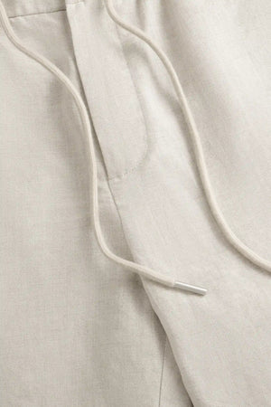 Close-up of the adjustable drawstring waistband on men’s driftwood beige linen-Tencel trousers.