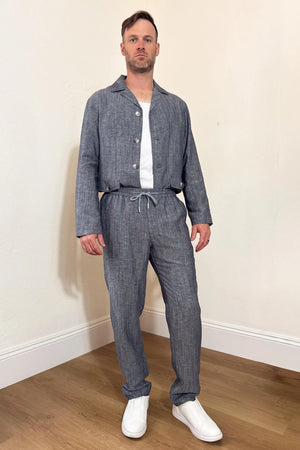 Front view of men’s heather grey linen-Tencel drawstring trousers styled with a matching jacket for an easy, travel-ready look.