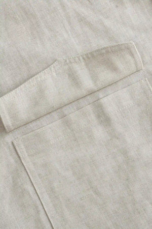 Detail view of the utility pocket on a men’s driftwood beige linen-Tencel safari jacket.