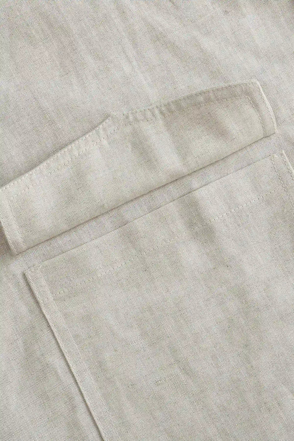 Detail view of the utility pocket on a men’s driftwood beige linen-Tencel safari jacket.
