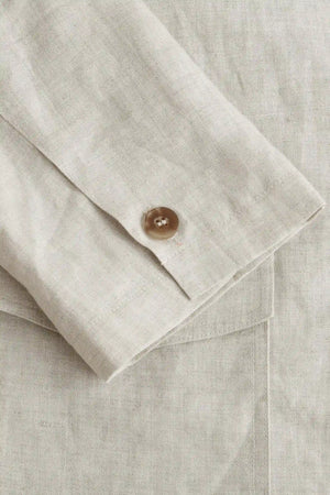 Detail view of the sleeve construction on a men’s driftwood beige linen-Tencel safari jacket.