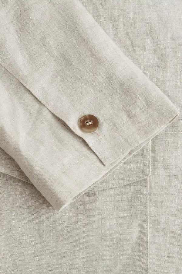 Detail view of the sleeve construction on a men’s driftwood beige linen-Tencel safari jacket.