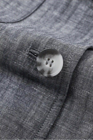 Detail view of the button closure on a men’s heather grey linen-Tencel safari jacket.