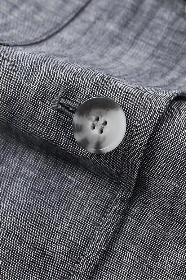Detail view of the button closure on a men’s heather grey linen-Tencel safari jacket.
