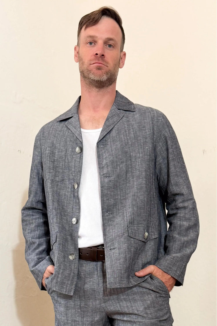 Front view of a men’s heather grey linen-Tencel safari jacket styled with matching trousers for a clean, warm-weather look.
