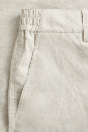Detail view of the front pocket on men’s driftwood beige linen-Tencel tailored shorts.