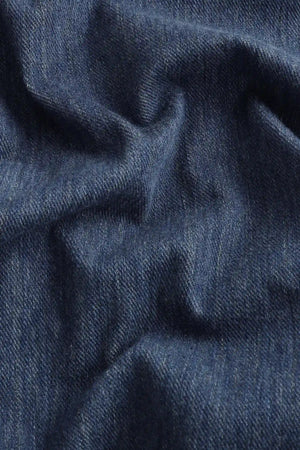 Close-up of the indigo rinse structured denim fabric, highlighting a crisp hand feel and refined texture.