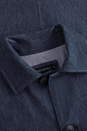 Angled close-up of the collar construction on a men’s indigo rinse utility denim overshirt jacket.