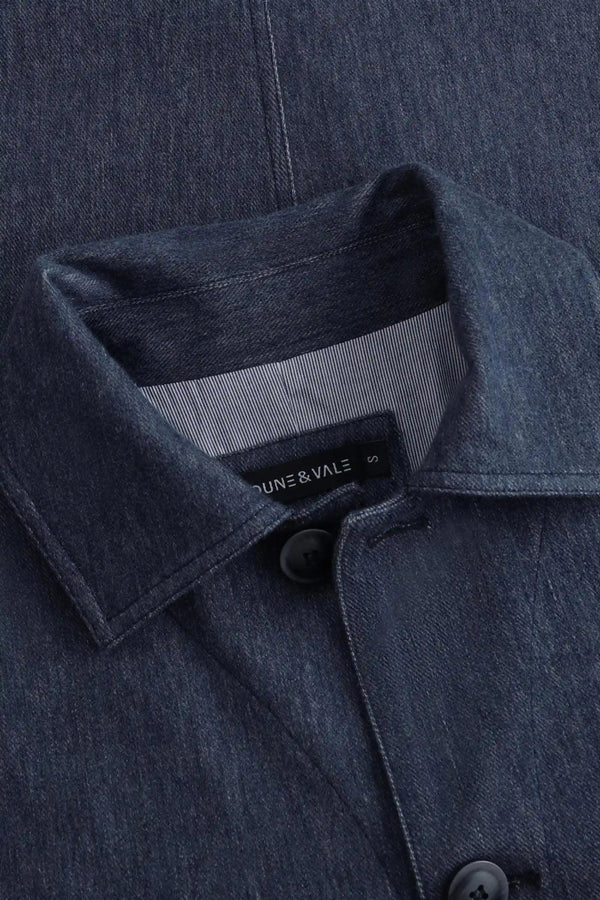 Angled close-up of the collar construction on a men’s indigo rinse utility denim overshirt jacket.