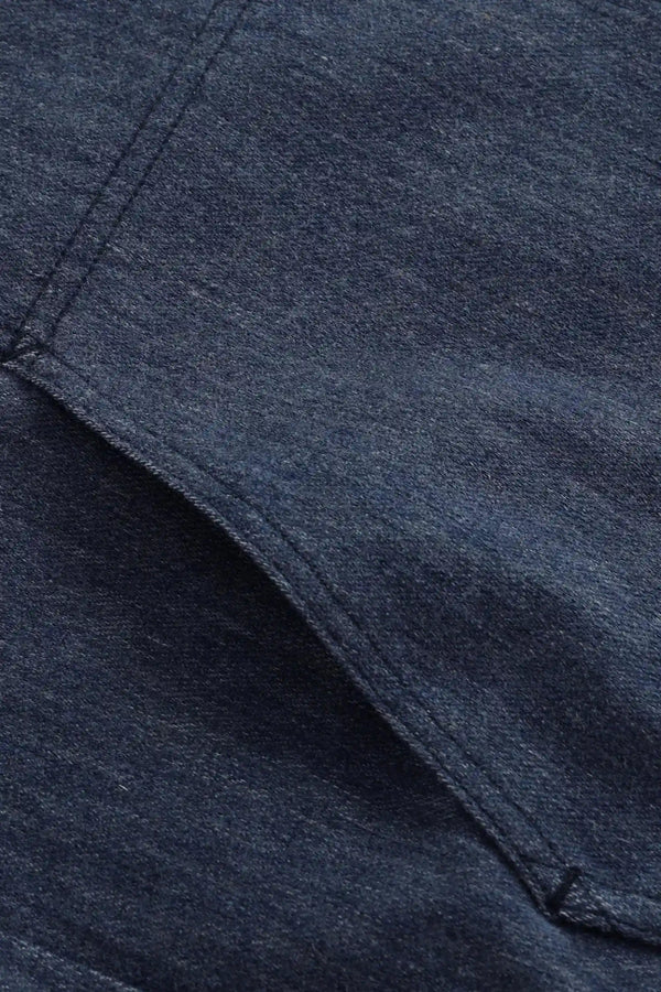 Detail view of the utility pocket on a men’s indigo rinse denim overshirt jacket.