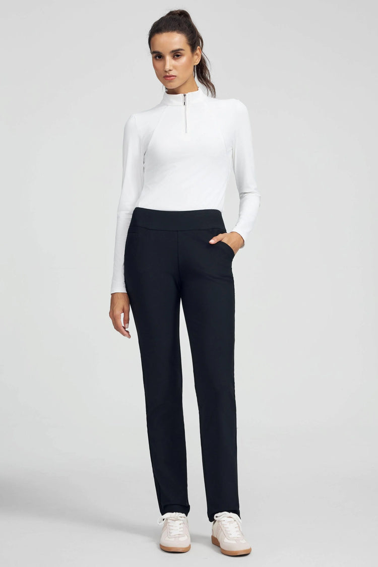 Woman wearing VEZA onyx black 4-way stretch tailored pant styled with a white performance top, front view