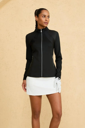 Woman wearing VEZA onyx black peplum mesh-panel zip jacket with UPF 50+, styled with a white skirt, front view