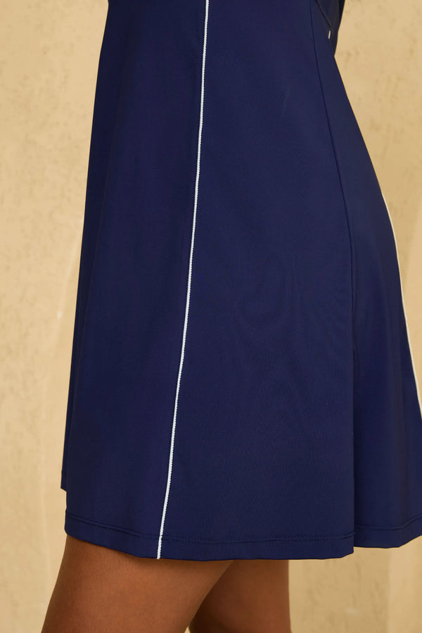 Close-up of VEZA midnight swing navy blue sleeveless golf dress showing the clean A-line hem design