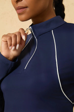 Close-up of VEZA midnight swing navy blue quarter-zip performance top highlighting the piped neckline and zip detail