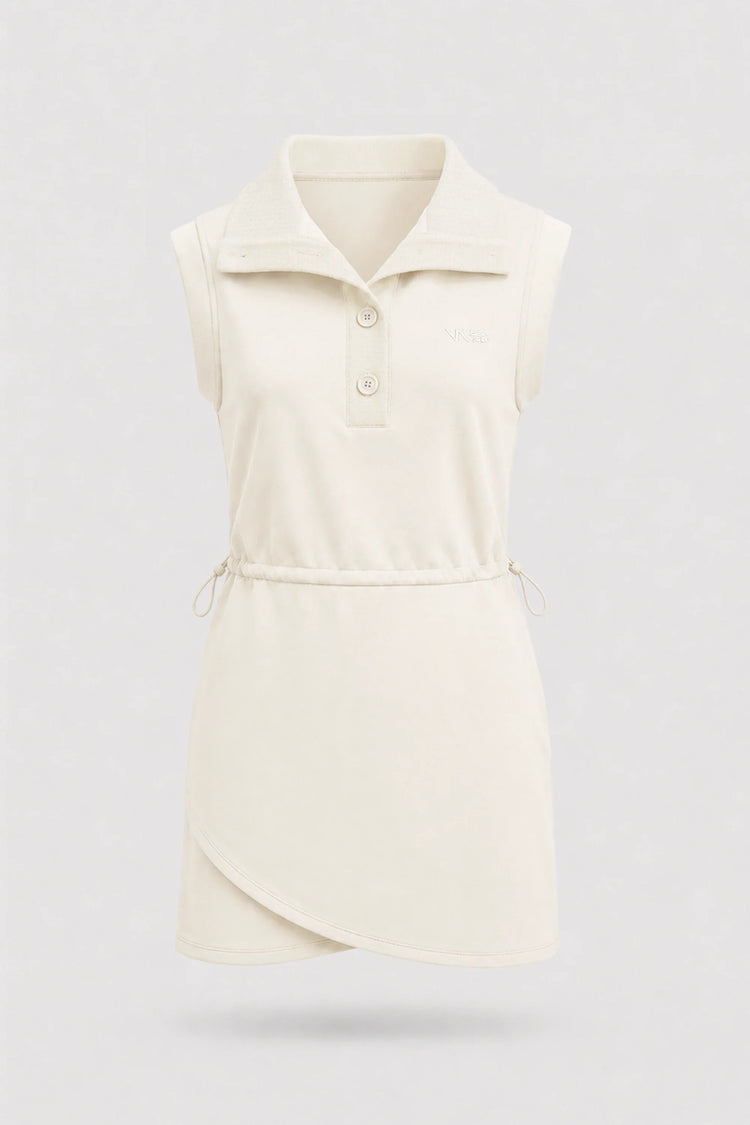Front view of women's ivory sleeveless golf dress with folded collar, adjustable drawcord waist and asymmetric wrap hem