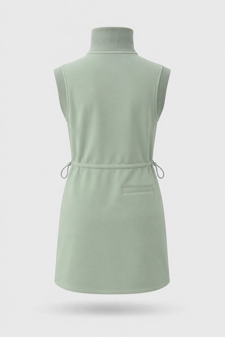 Back view of women's sage green sleeveless golf dress with stand collar, adjustable drawcord waist and back pocket