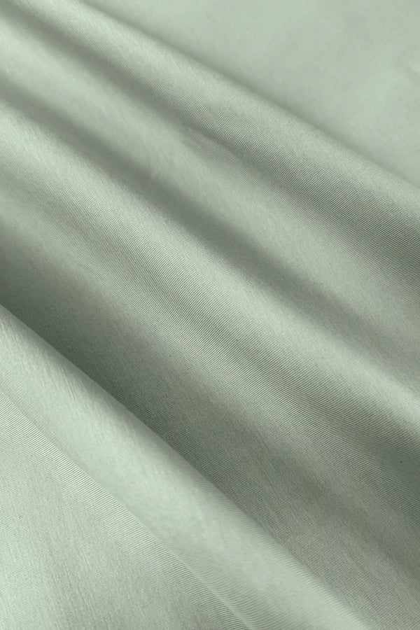 Close-up of the smooth light green fabric texture of the women’s sleeveless golf dress