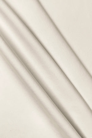 Close-up of the smooth ivory fabric texture of the women’s sleeveless golf dress