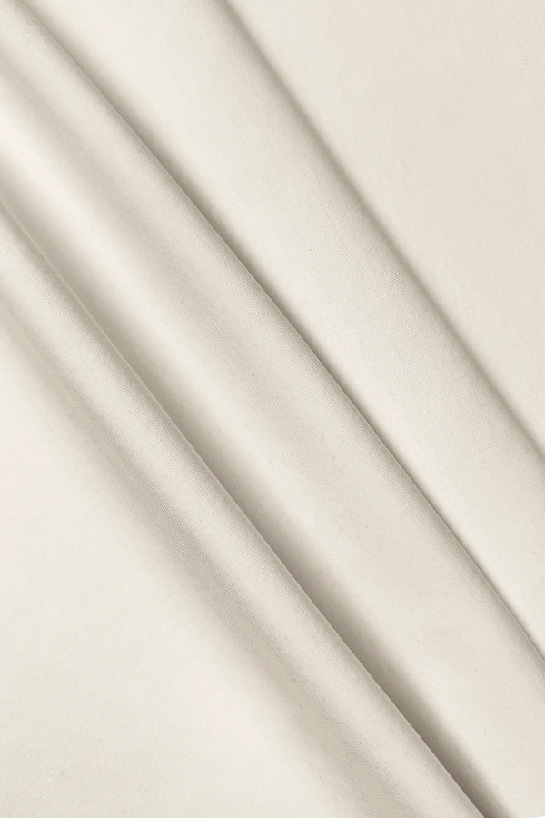 Close-up of the smooth ivory fabric texture of the women’s sleeveless golf dress